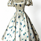 Robe midi bleu satiné à manches bouffantes et col carré, style rétro, idéale pour une soirée légère ou un rendez-vous amoureux (NV6804)